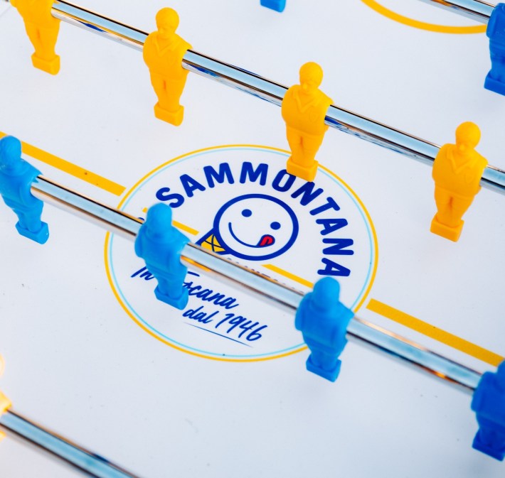 Blue and yellow foosball table featuring Sammontana branding