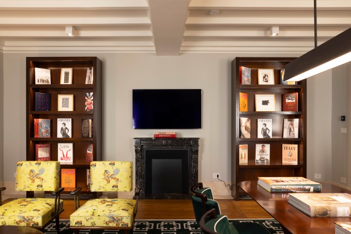 Lounge with built-in bookshelves inside Casa J.K. Place Roma.