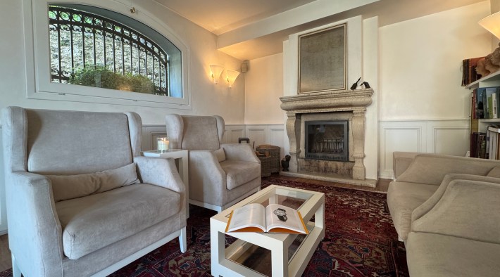 Sitting room with fireplace and armchairs at Albergo Al Sole in Asolo