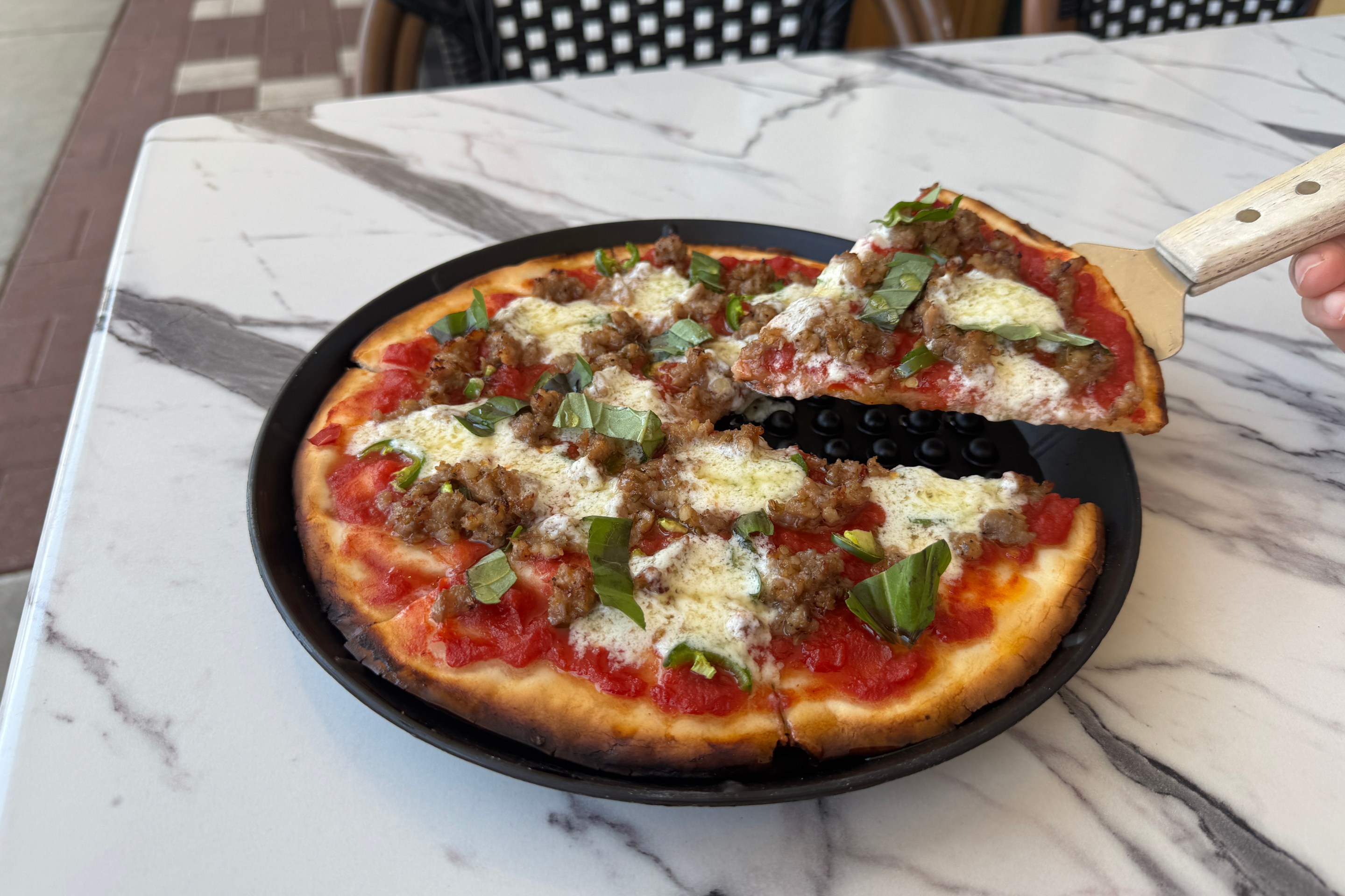 Gluten-free pizza topped with sausage, basil and cheese at Baldinucci Pizza Romana in Austin.