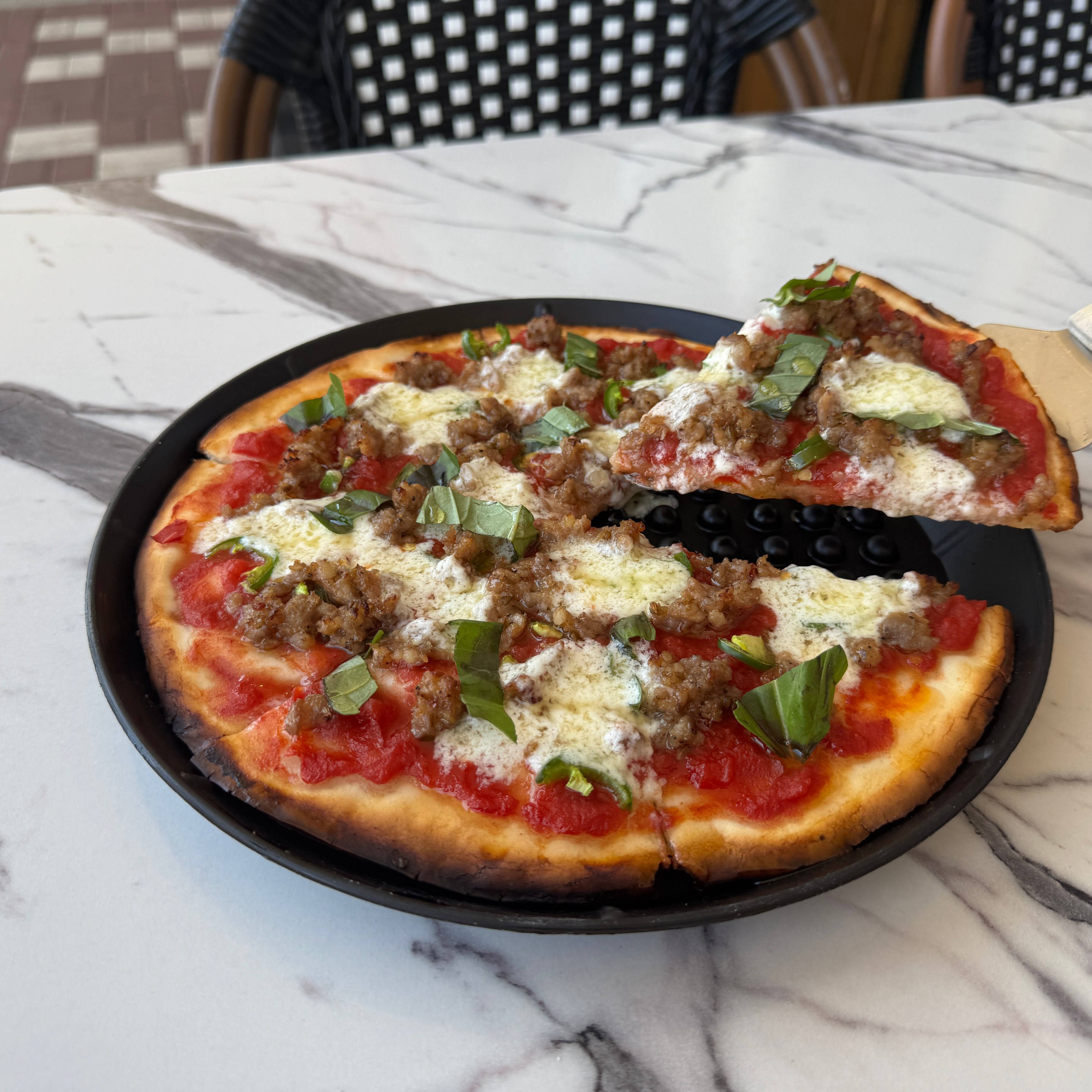 Gluten-free pizza topped with sausage, basil and cheese at Baldinucci Pizza Romana in Austin.
