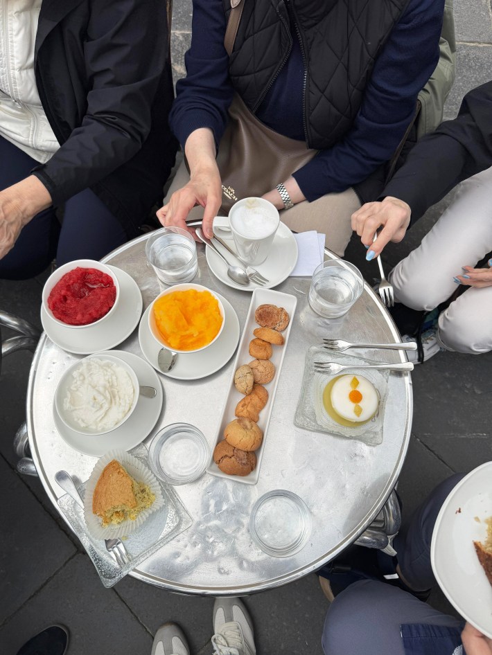 Breakfast at Caffe Scilia with fruit, cookies and coffee, around a round table