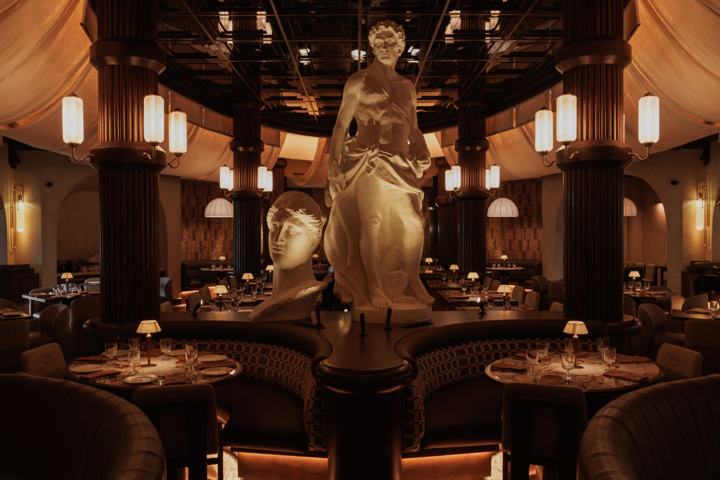 Roman God of Fire dining room in Tempe featuring Roman statues, columns and warmly lit tables.