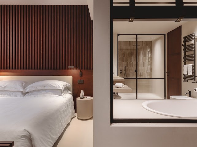 Suite at Capitolo Riviera with a white bed and open bathroom