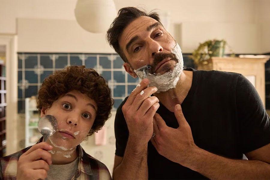 A man and young boy shave side by side in a bathroom during a playful scene from the Italian film Life Is Life.