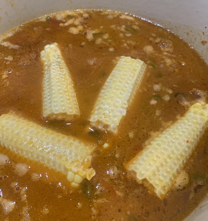Corn cobs simmering in a pot of Italian vegetable soup.