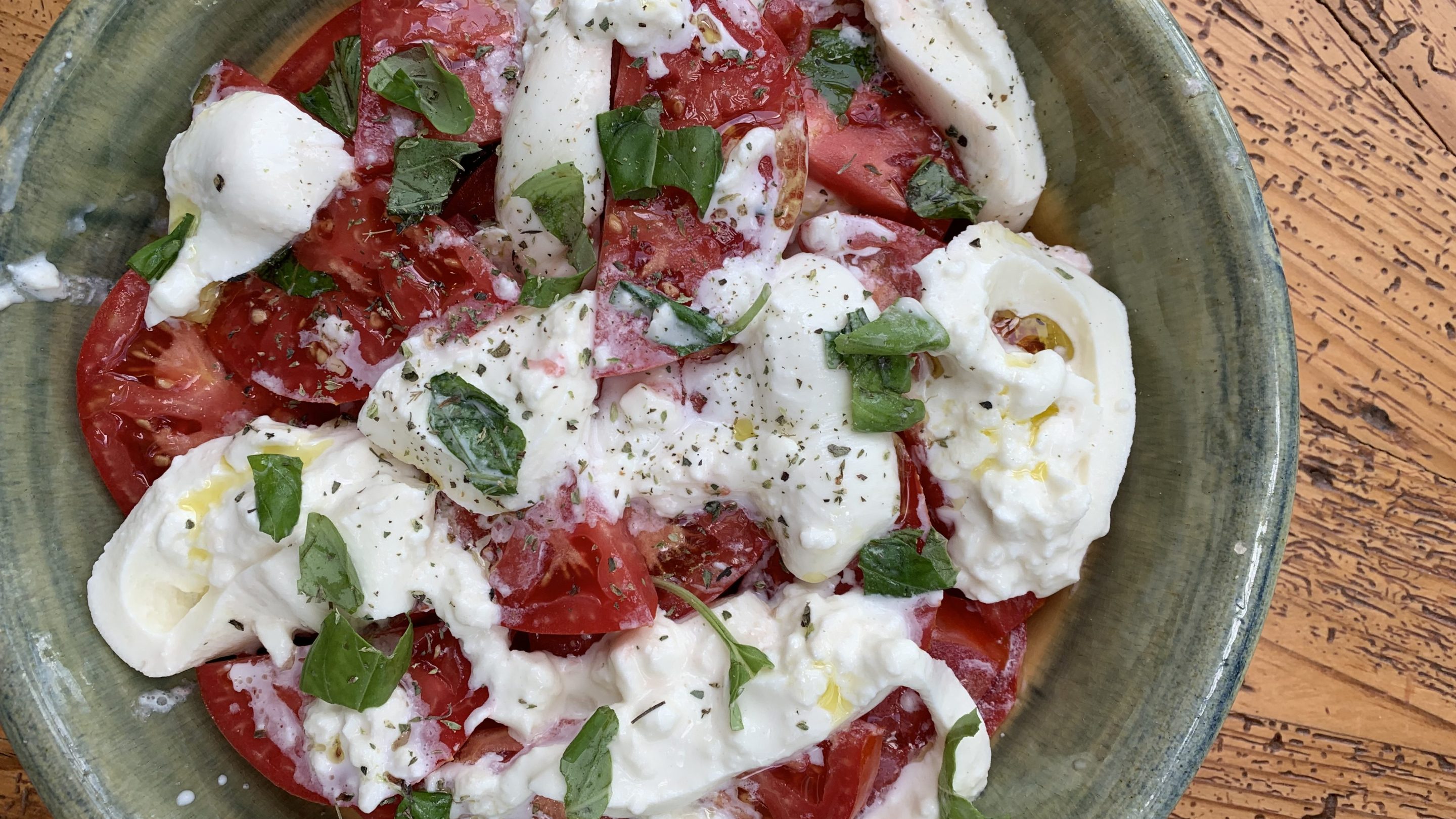 Summer tomatoes with creamy burrata, fresh basil, oregano and olive oil.