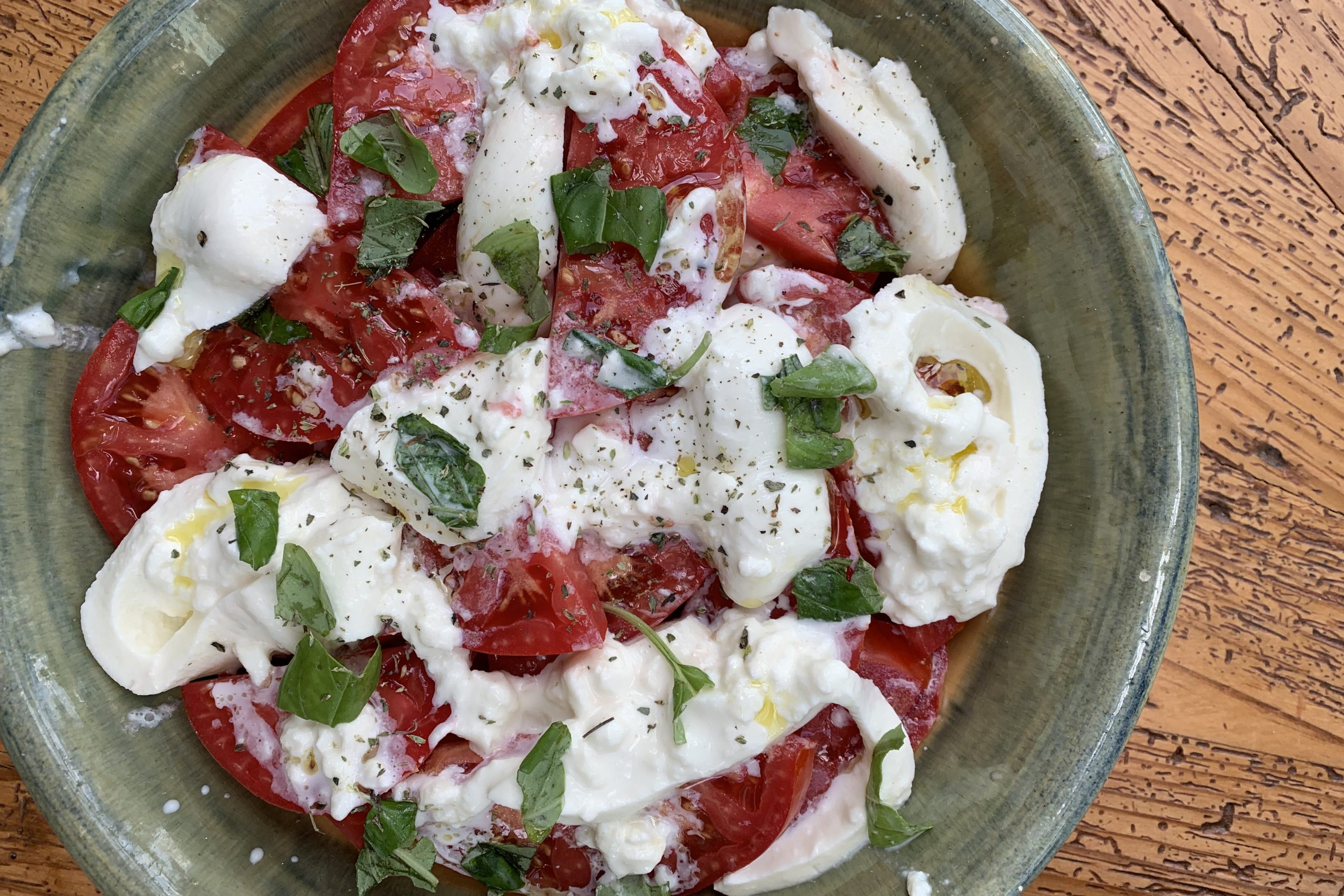 Summer tomatoes with creamy burrata, fresh basil, oregano and olive oil.