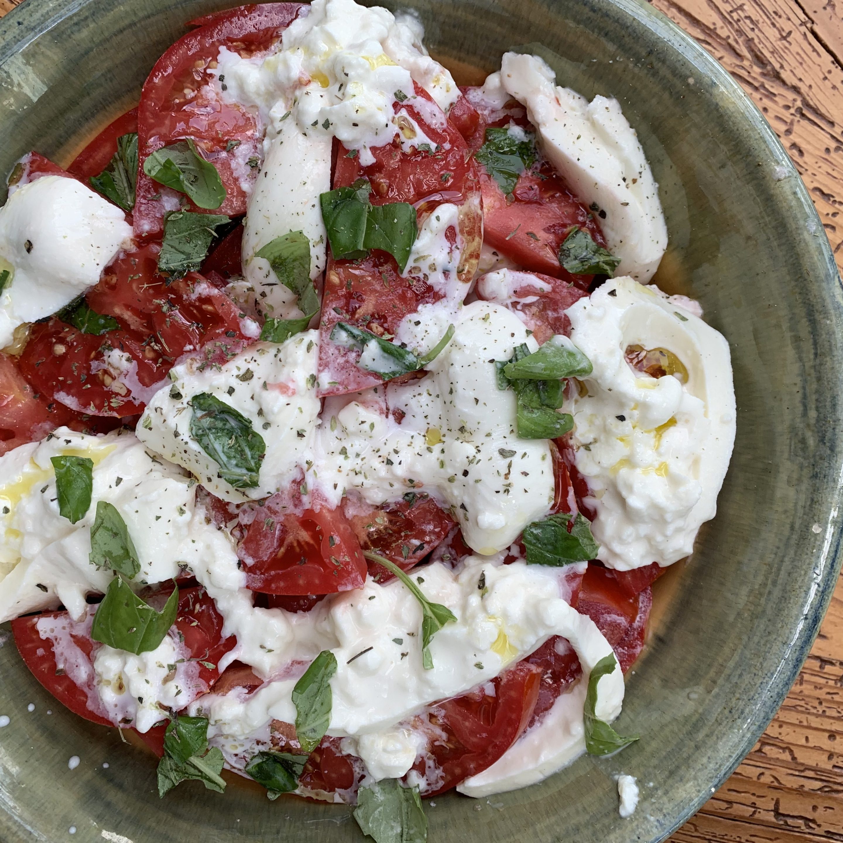 Summer tomatoes with creamy burrata, fresh basil, oregano and olive oil.