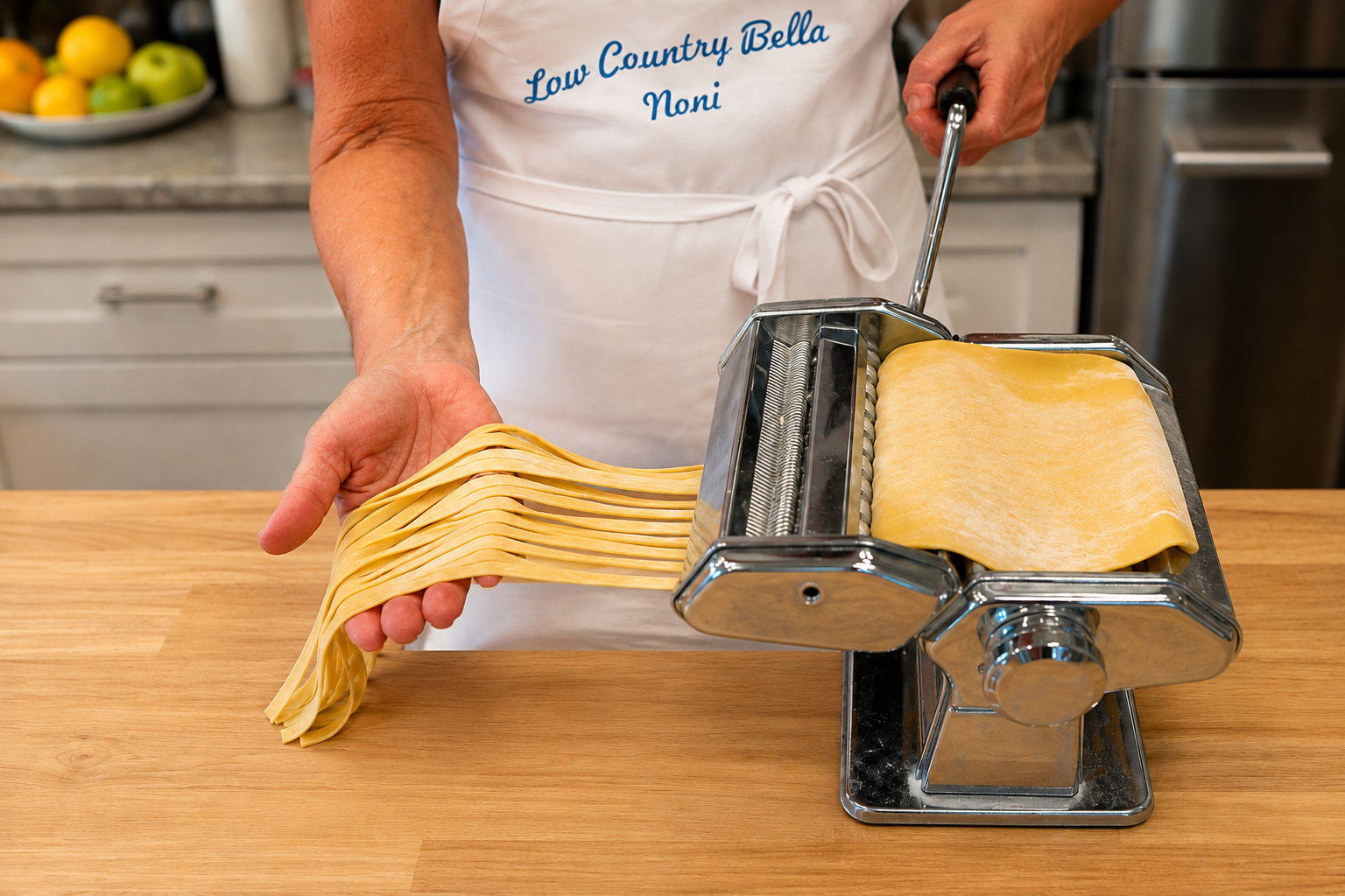 Lowcountry Bella cutting fresh fettuccine with a hand-crank pasta machine.