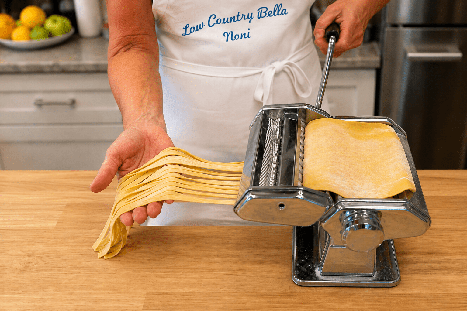 Lowcountry Bella cutting fresh fettuccine with a hand-crank pasta machine.