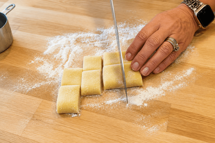 Hand-cutting fresh pasta dough into pappardelle.