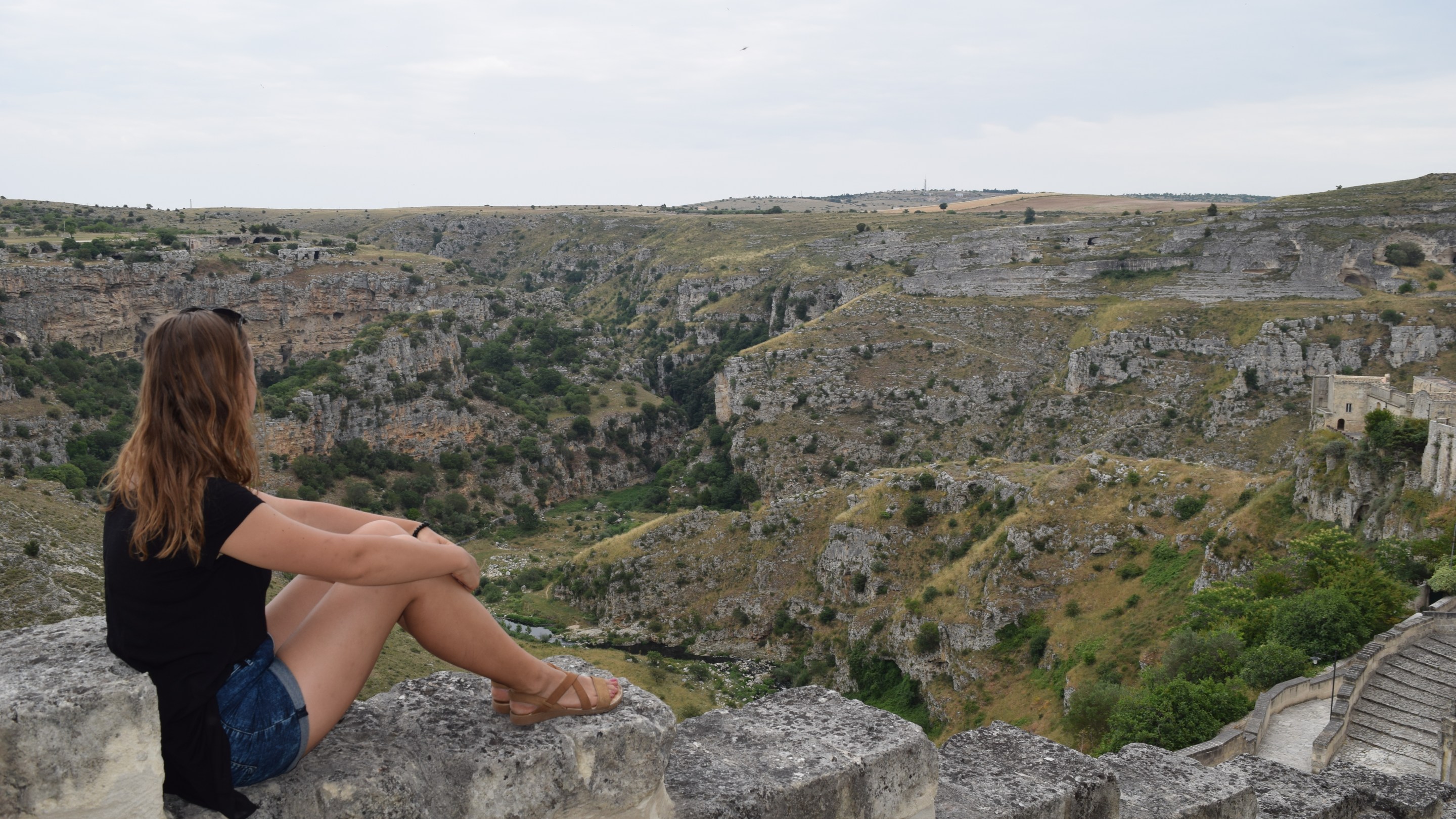 The author Sandra Ulewicz overlooking the rocky ravine and landscape surrounding Matera, Italy.