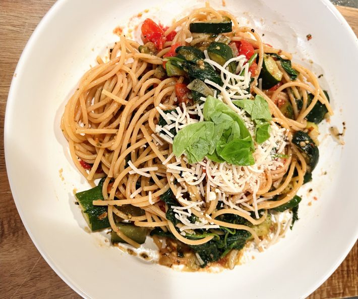 Spaghetti with fresh vegetables, basil and cheese.