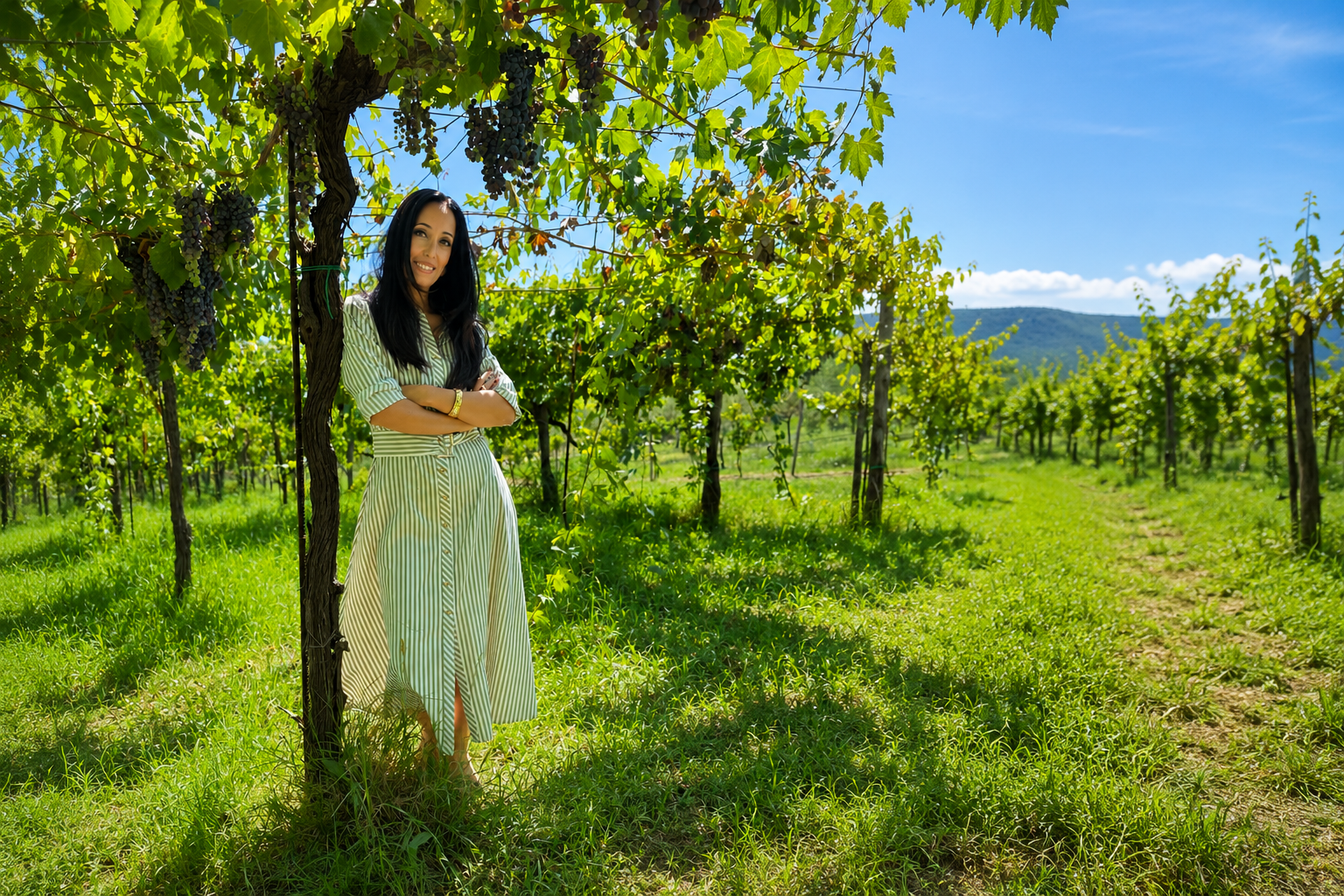 Teresa Mincione in vineyards in a long green and white dress