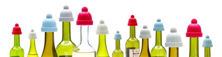 Wine bottles topped with colorful knit-hat-shaped Beanie bottle stoppers from Monkey Business