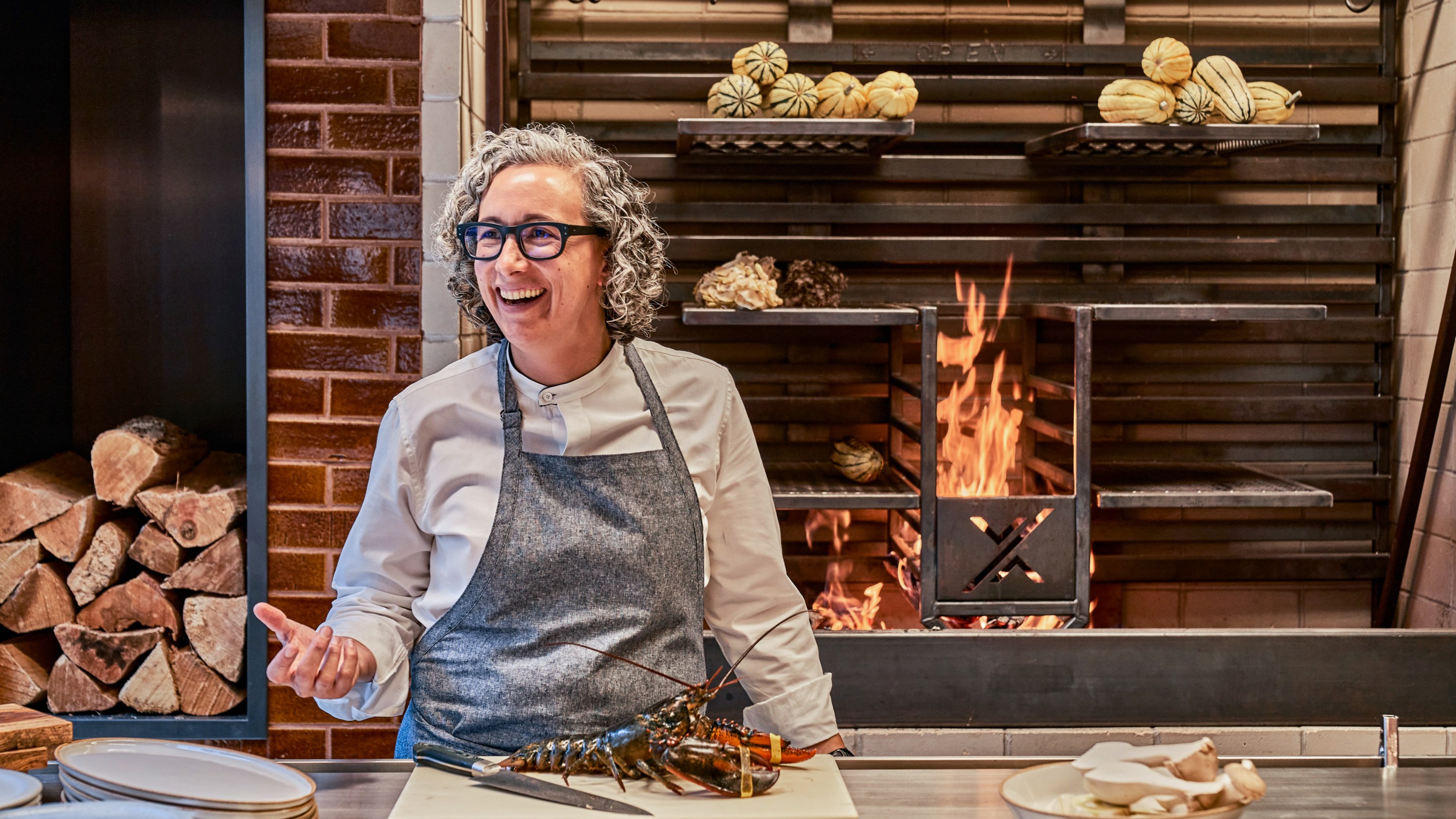 Chef Hillary Sterling in the kitchen with a lobster on a cutting board in front of her. Photo credit: Giada Paoloni