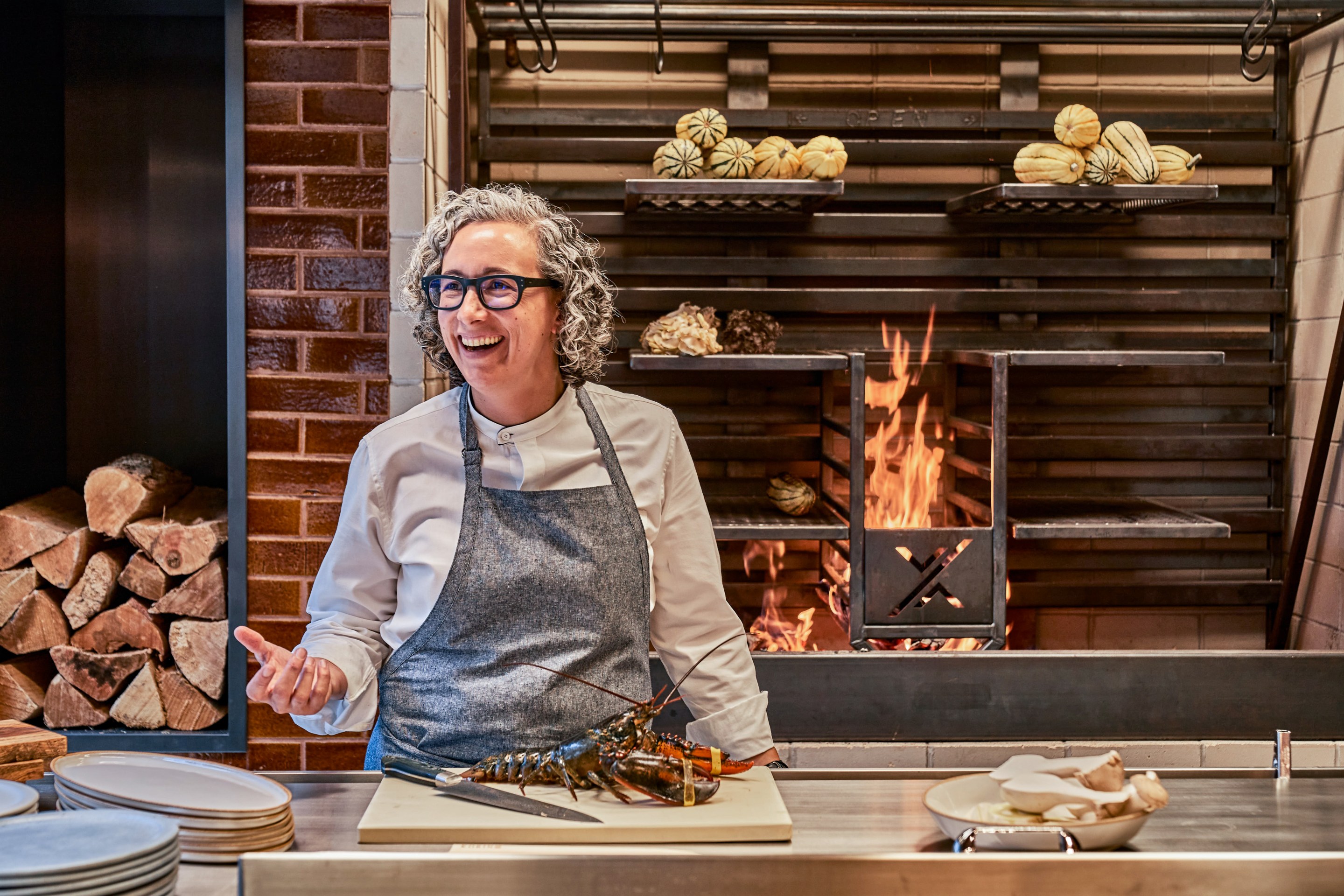 Chef Hillary Sterling in the kitchen with a lobster on a cutting board in front of her. Photo credit: Giada Paoloni