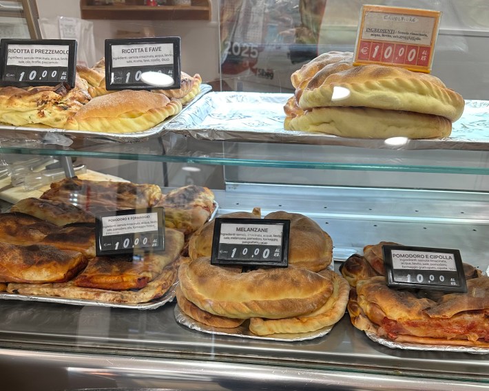 Savory breads and pastries displayed at a bakery in Modica Sicily.