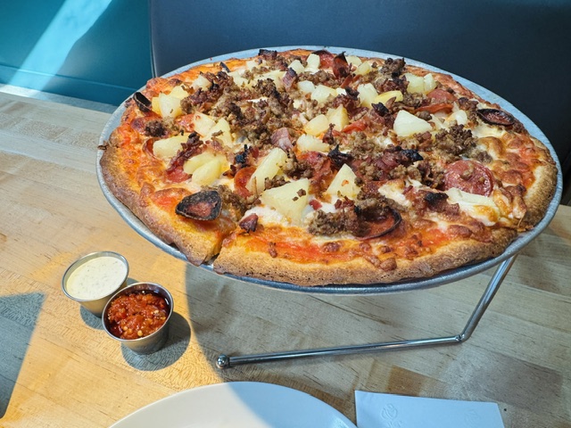 Gluten-free pizza topped with meat, pineapple and pepperoni at Love Supreme Pizza Bar in Austin.