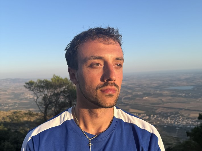 Anthony Castelvecchi standing on a hillside overlooking the Sicilian countryside.