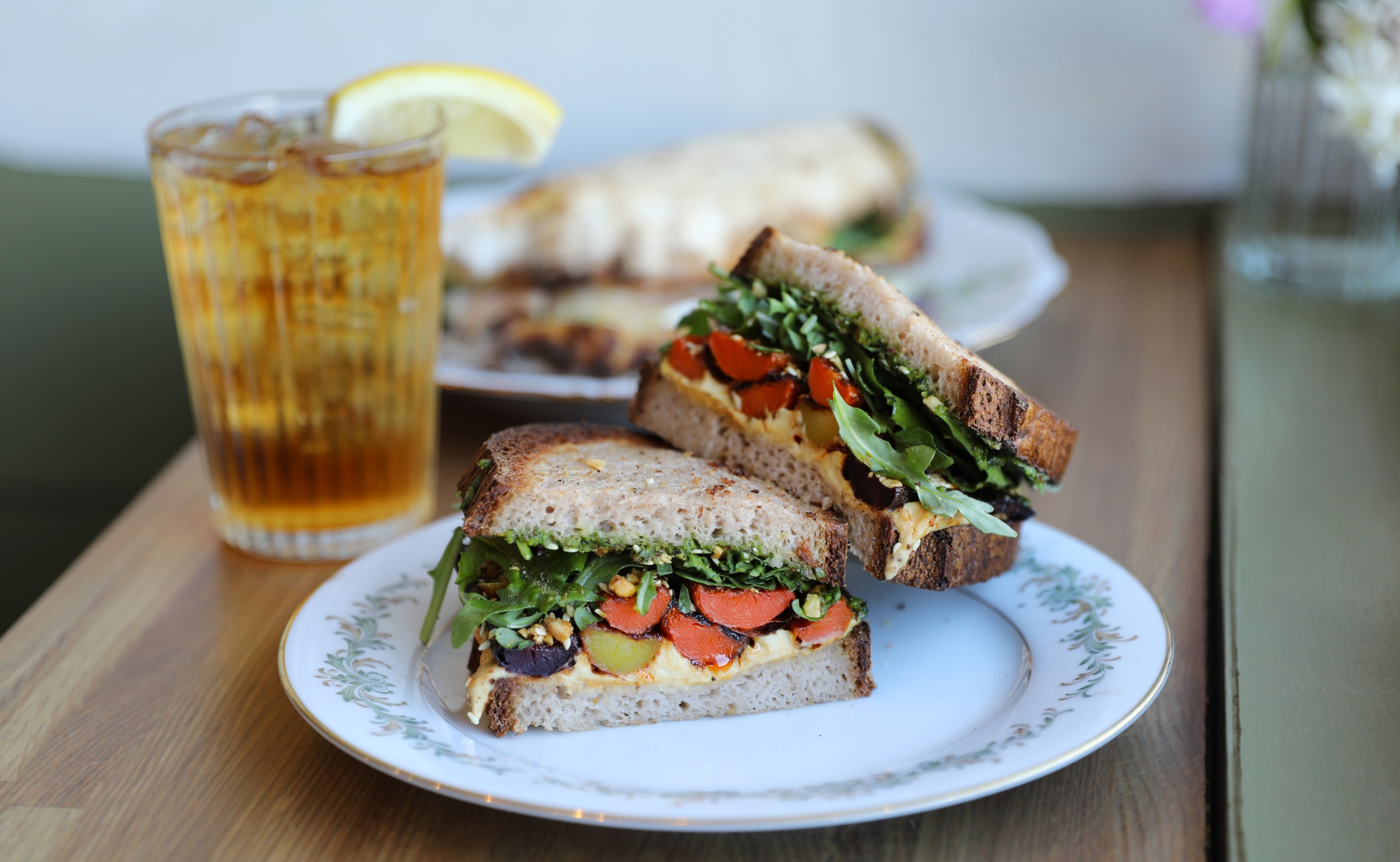 Gluten-free sandwich with roasted carrots, hummus, pesto and arugula.