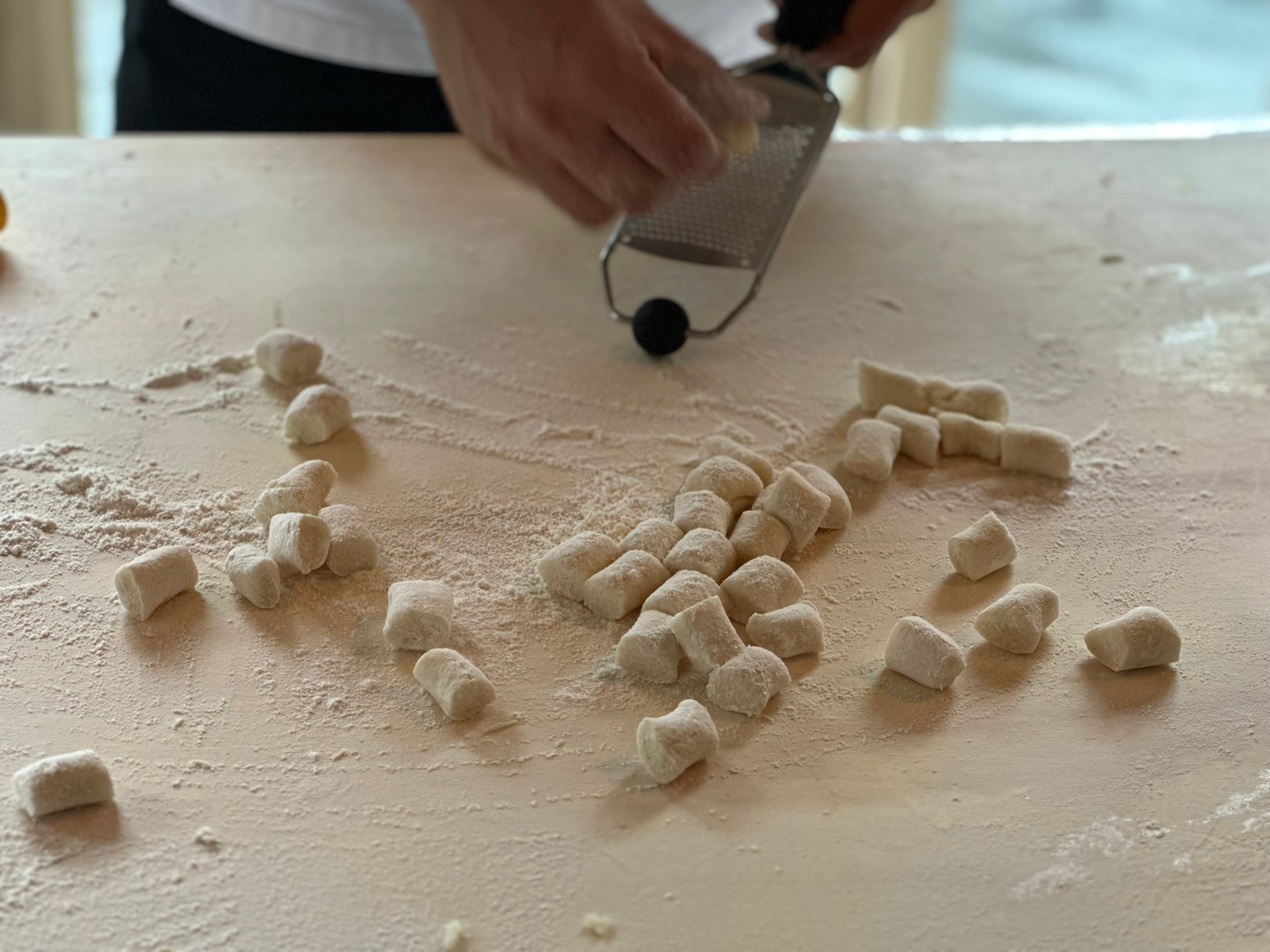 Fresh gnocchi being cut on a floured work surface. Image 4