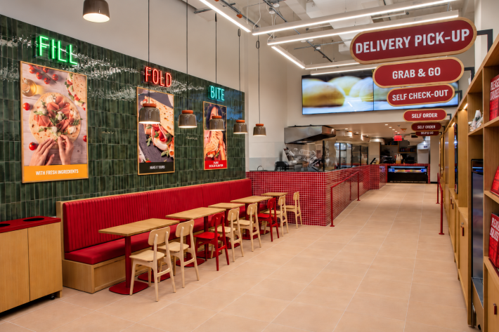 Piadi restaurant interior with red booth seating, tables and an ordering counter.