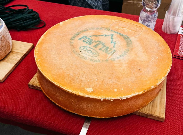 Wheel of Fontina DOP cheese bearing the official certification mark