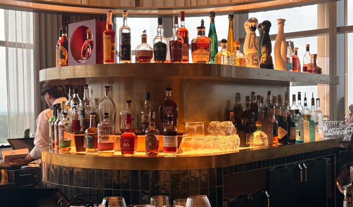 Curved bar lined with liquor bottles inside Turning Stone Resort Casino