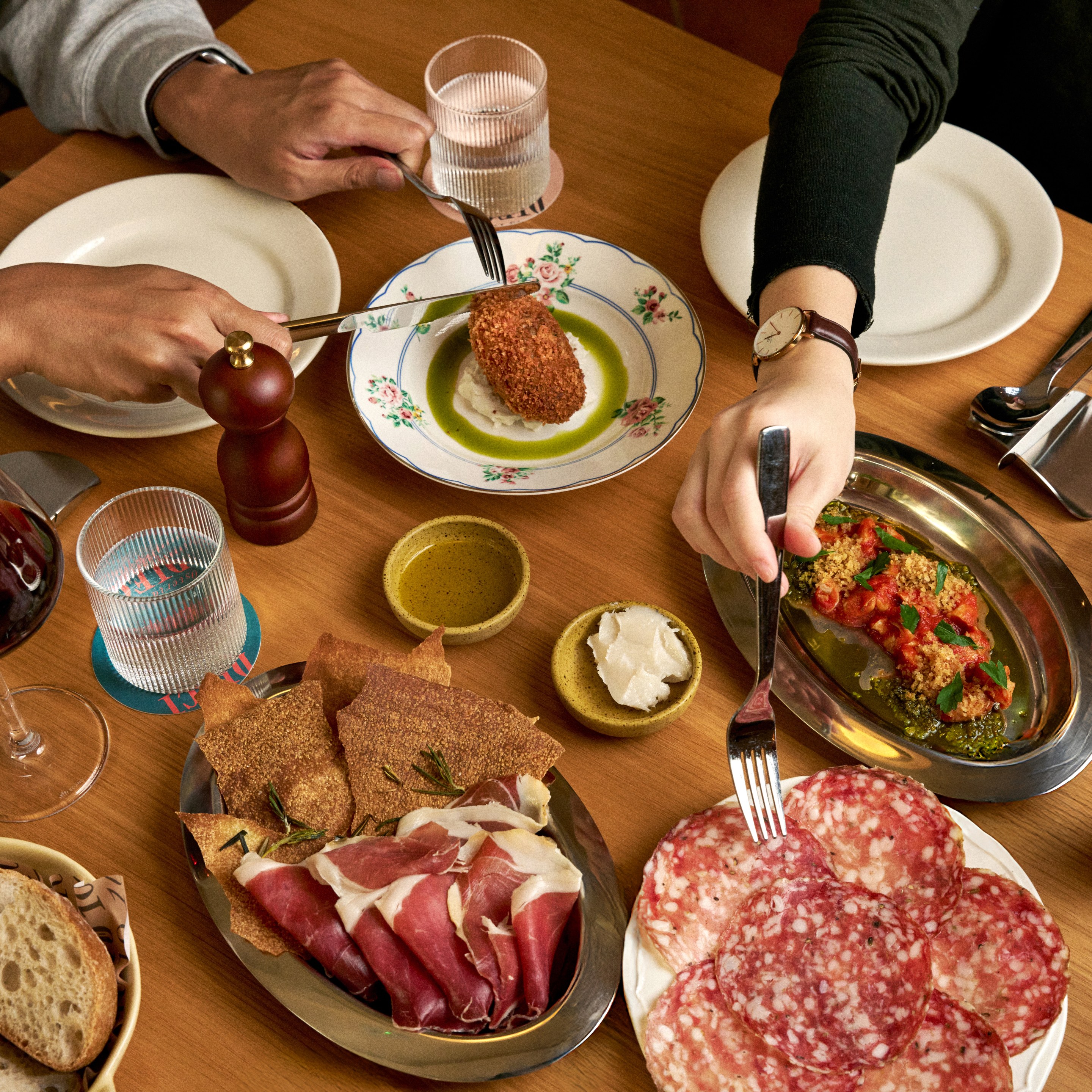 Rustic bread “Amo ago” Bakery, Oxtail suppli, Colli etruschi olive oil, Lardo battuto, Local sea snail in spicy tomato sauce, Finocchiona salami, Giancarlo Tanara 24-month prosciutto di Parma at DIECI in Hong Kong. Photo: DIECI, Paolo Olivieri