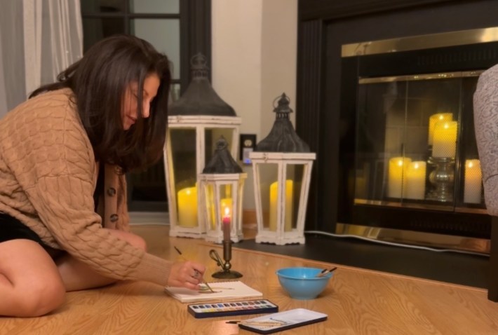 the author watercoloring on the floor in her apartment