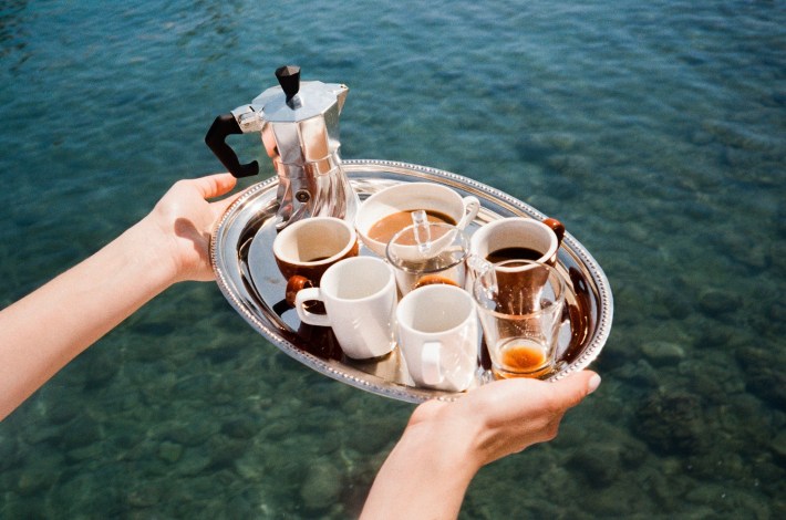 Turbo Moka and coffee cups on a tray beside the water