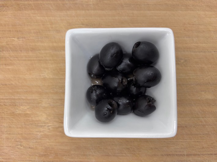 Black olives in a white bowl.