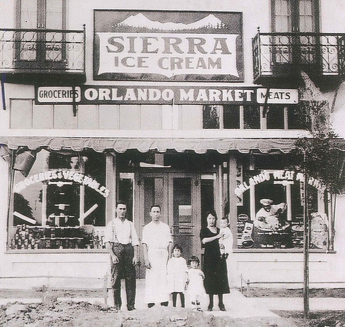 The Orlando family stands outside Orlando Market in Fresno, California, circa 1930s.