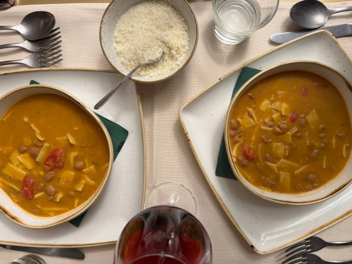 Two bowls of pasta e fagioli on a dining table.