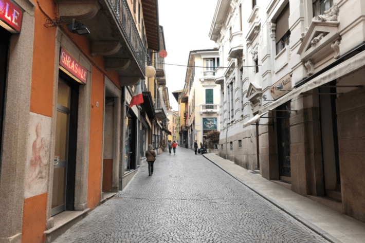Cobblestone street lined with buildings in Piedmont, Italy.