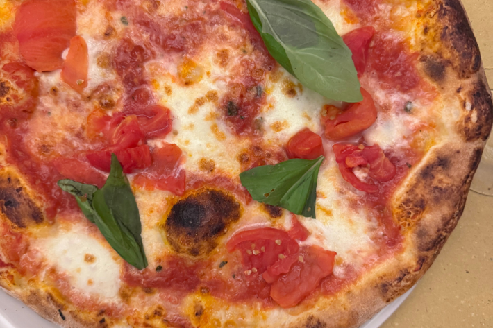 Pizza topped with tomato, cheese and basil.