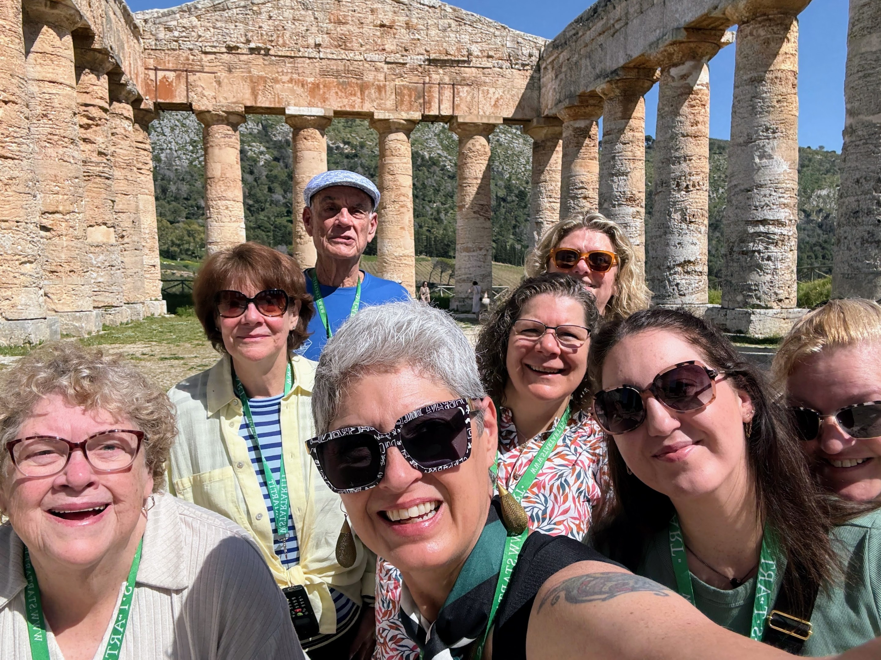 A group of visitors posing among ancient stone columns.