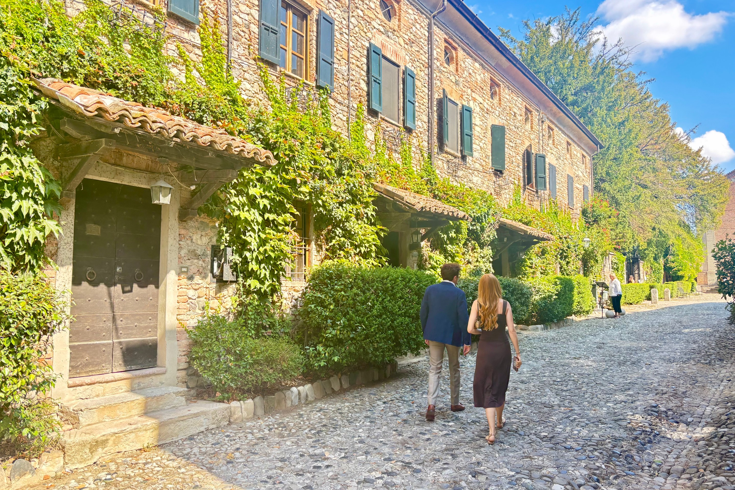 Visitors walking along a cobblestone street in Borgo di Rivalta