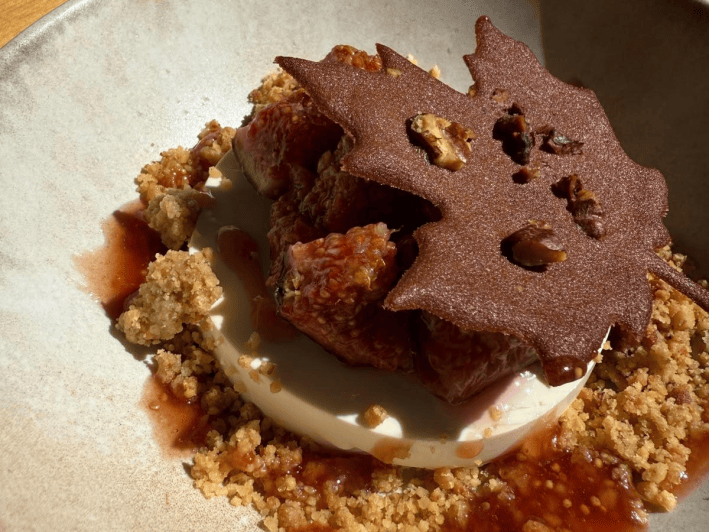 Fig dessert with a creamy base, crumble and a thin decorative topping.