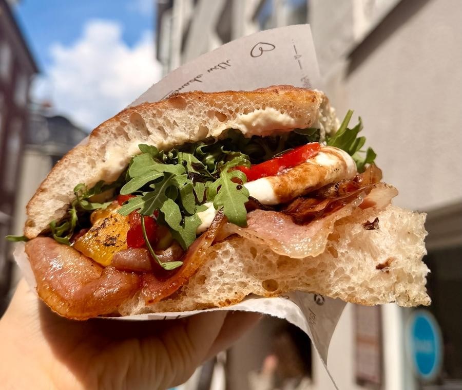 Focaccia sandwich filled with meat, vegetables and arugula.