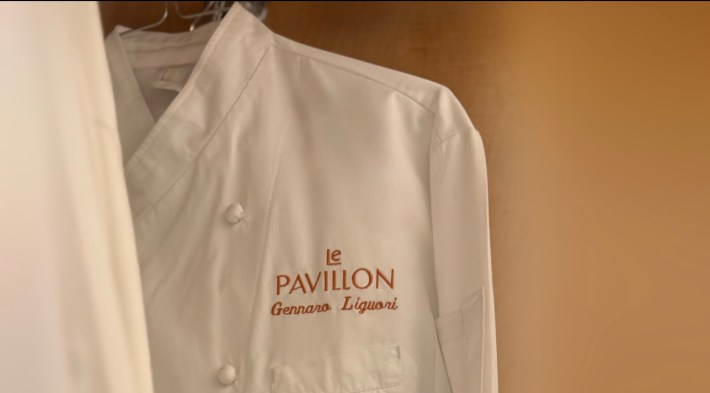 White chef’s jacket embroidered with Le Pavillon and Gennaro Liguori’s name.