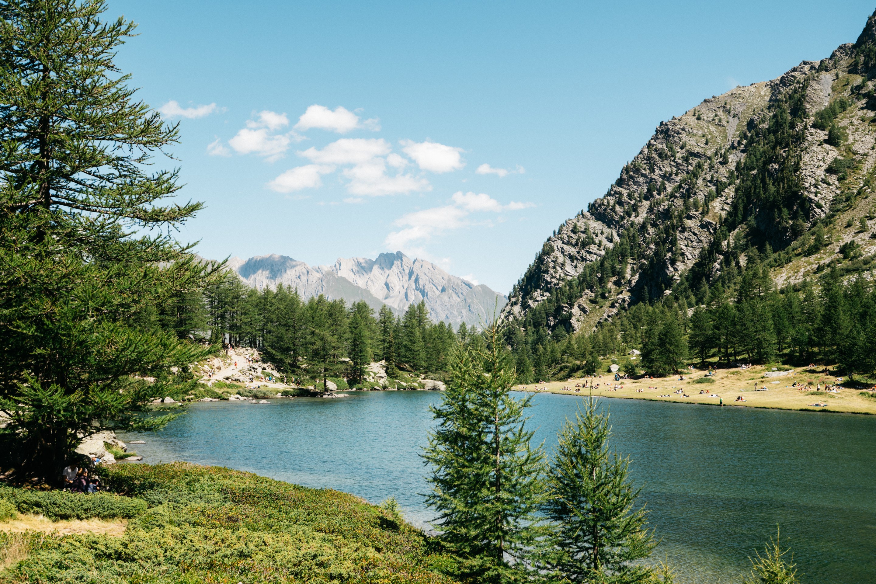 Lago d’Arpy surrounded by trees and rocky mountains in Italy’s Aosta Valley.