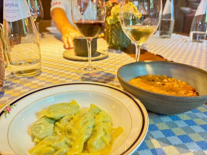 Stuffed pasta beside a bowl of dumplings with beans and tomato sauce