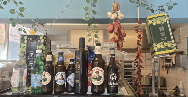 Olive oil tins, drink bottles and hanging garlic, onions and peppers at La Posata 2.