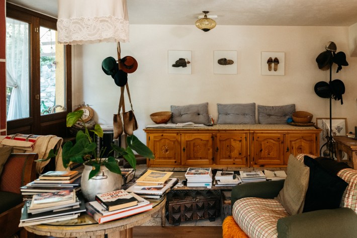 Kitchen at Maison Le Champ with wooden counter stools, cookware and a hanging chandelier.