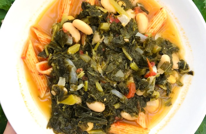White bean soup with leafy greens, penne and tomatoes.